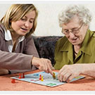 Caregiver playing a board game with a client