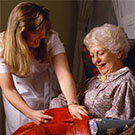 Caregiver putting a blanket on a clients legs